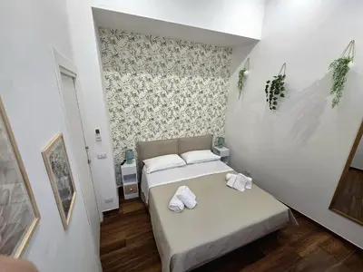 a small room with two beds and a wall at Angelina Rooms in Palermo