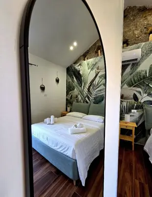 a bedroom with a bed and a mirror at Angelina Rooms in Palermo