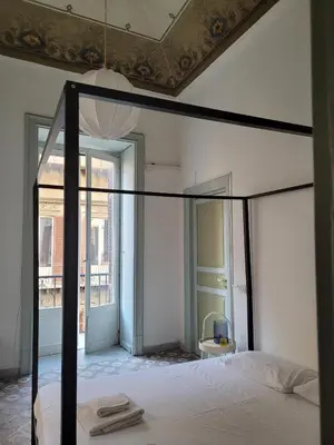 a bedroom with a bed with a black canopy at MojoCoHouse in Palermo