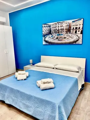 a blue bedroom with a bed with towels on it at Santerasmo Rooms king in Palermo