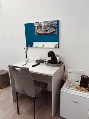 a white desk with a chair and a picture on the wall at Santerasmo Rooms king in Palermo