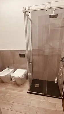 a bathroom with a toilet and a glass shower at Santerasmo Rooms king in Palermo