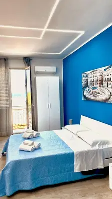 a blue bedroom with a bed with towels on it at Santerasmo Rooms king in Palermo