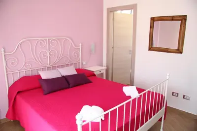 a bedroom with a large bed with a red blanket at B&B Menta & Peperoncino in Partinico