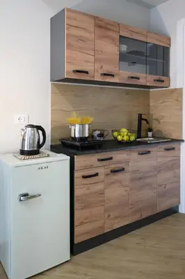 a kitchen with wooden cabinets and a white refrigerator at Oros rooms in Palermo
