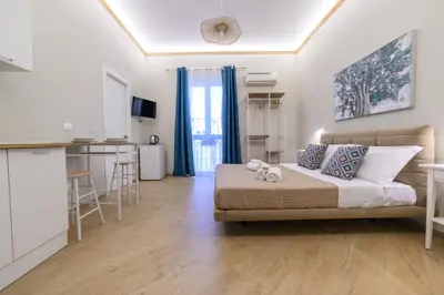 a living room with a bed and a kitchen at Oros rooms in Palermo