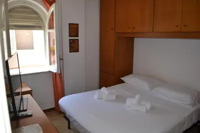a bedroom with a bed with white sheets and a window at La Dimora di Alice in Palermo