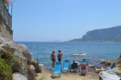 a group of people sitting in chairs on the beach at La Dimora di Alice in Palermo