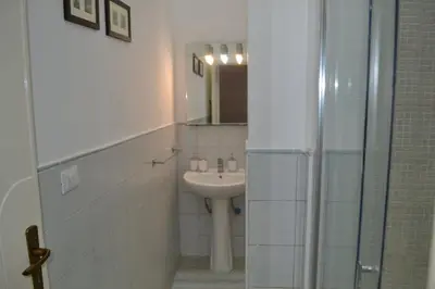 a white bathroom with a sink and a mirror at La Dimora di Alice in Palermo