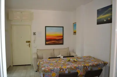 a dining room with a table and a couch at La Dimora di Alice in Palermo