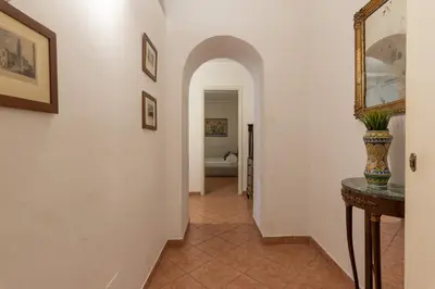 a hallway with white walls and a vase on a table at Real Umberto Apartments by Wonderful Italy in Palermo