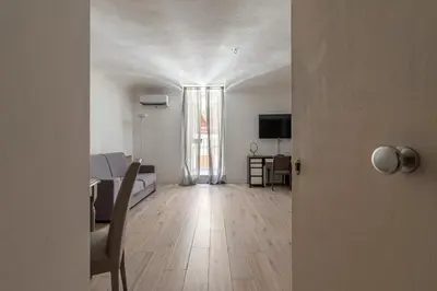 a room with a bed and a room with a television at Real Umberto Apartments by Wonderful Italy in Palermo