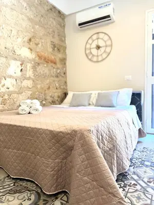 a bedroom with a bed with a clock on the wall at La Casetta dell'Architetto in Cinisi