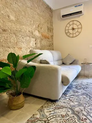 a living room with a couch and a plant at La Casetta dell'Architetto in Cinisi