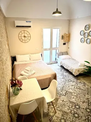 a bedroom with two beds and a table and chairs at La Casetta dell'Architetto in Cinisi
