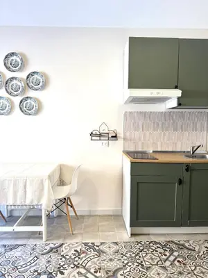 a kitchen with green cabinets and a table at La Casetta dell'Architetto in Cinisi