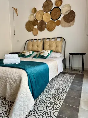 a bedroom with a bed with hats on the wall at La Casetta dell'Architetto in Cinisi
