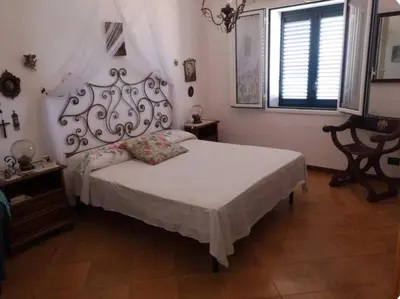 a bedroom with a bed with a white bedspread and a window at Villa Adele in Trappeto