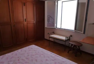 a bedroom with a bed and a window and a bench at Villa Adele in Trappeto