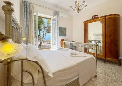 a bedroom with a bed and a large window at Solemar Sicilia - Palazzo Tiglio in Porticello