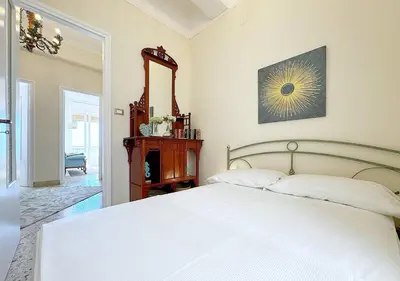 a bedroom with a white bed and a mirror at Solemar Sicilia - Palazzo Tiglio in Porticello