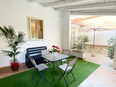 a patio with a table and chairs and an umbrella at Il Vialetto in Mondello