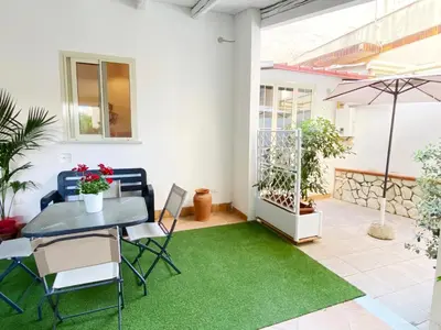 a patio with a table and a green rug at Il Vialetto in Mondello