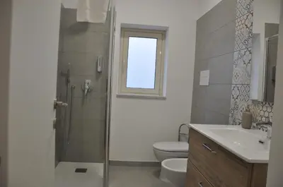 a bathroom with a shower and a toilet and a sink at Casa Giovannella in Palermo