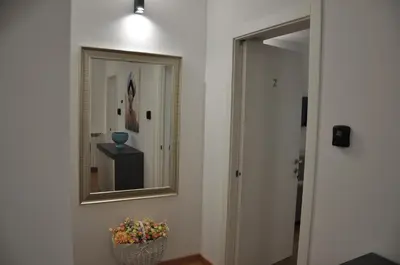 a hallway with a mirror and a vase of flowers at Casa Giovannella in Palermo