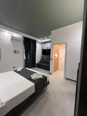 a bedroom with a large bed and a couch at kumpa' sicilian apartments in Palermo