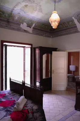 a bedroom with a bed and a chandelier at Casa Tramontana Ospitalità Diffusa in Castronuovo di Sicilia