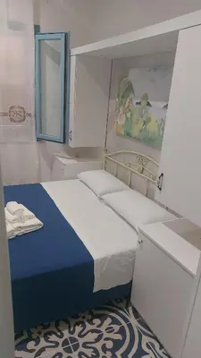 a small bedroom with a bed and a mirror at Benvenuti al Sud B&B in Macari