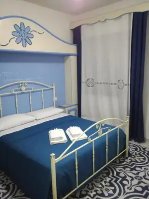 a bedroom with a blue bed with towels on it at Benvenuti al Sud B&B in Macari