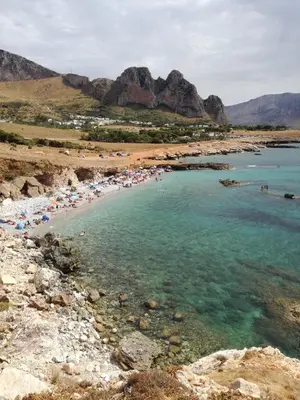 a beach with a bunch of people in the water at Benvenuti al Sud B&B in Macari