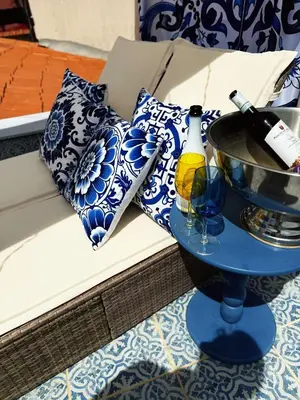 a blue and white couch with a bottle of wine on a table at Opera Dolce in Carini