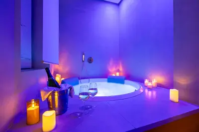 a bathroom with a tub with wine glasses and candles at Villa Libertà in Palermo