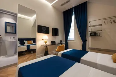 a hotel room with two beds and a bathroom at Villa Libertà in Palermo