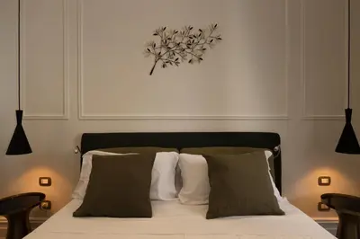 a bedroom with a bed with white and green pillows at Villa Libertà in Palermo