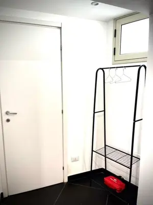 a room with a luggage rack next to a door at black d'ossuna in Palermo