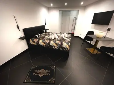 a bedroom with a bed and a table and a piano at black d'ossuna in Palermo