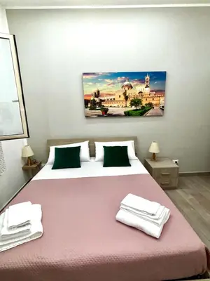 a bedroom with a large bed with towels on it at Santerasmo Rooms standard in Palermo