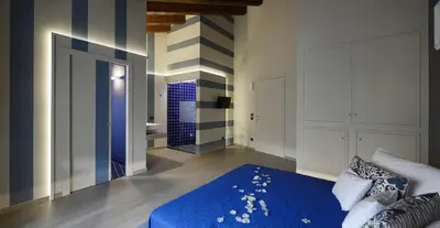a bedroom with a blue bed and a bathroom at Agrirelais Principe SPA in San Giuseppe Jato