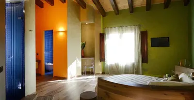 a bedroom with green and orange walls and a bed at Agrirelais Principe SPA in San Giuseppe Jato