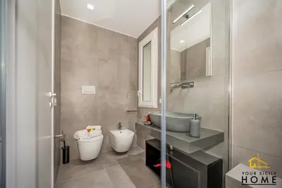 a bathroom with a sink and a toilet and a shower at Appartamenti in villa Ionio vista mare con piscina riscaldata e campo da bocce in Alcamo