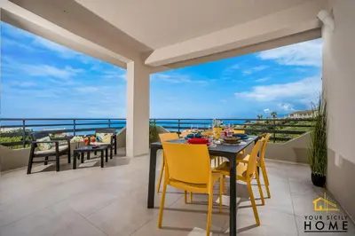a dining room with a view of the ocean at Appartamenti in villa Ionio vista mare con piscina riscaldata e campo da bocce in Alcamo