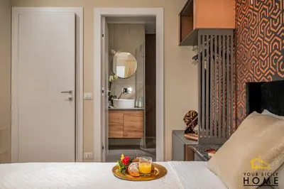 a bedroom with a bed with a plate of food on it at Appartamenti in villa Ionio vista mare con piscina riscaldata e campo da bocce in Alcamo