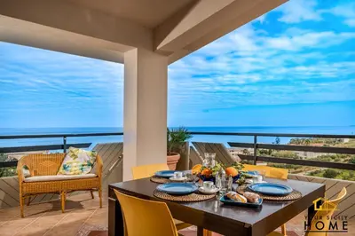 a table with plates of food on a balcony with a view at Appartamenti in villa Ionio vista mare con piscina riscaldata e campo da bocce in Alcamo