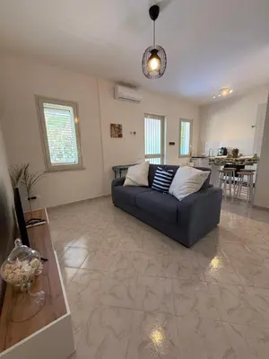 a living room with a couch and a table at Magaggiari Beach House in Cinisi