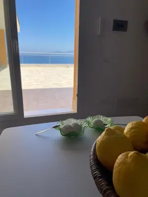 a basket of lemons on a table with a door at A' Terrazza in Santa Flavia