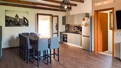 a kitchen with a table and chairs and a refrigerator at Villa Betta Cuntrariusa con piscina privata e jacuzzi a Scopello in Castellammare del Golfo